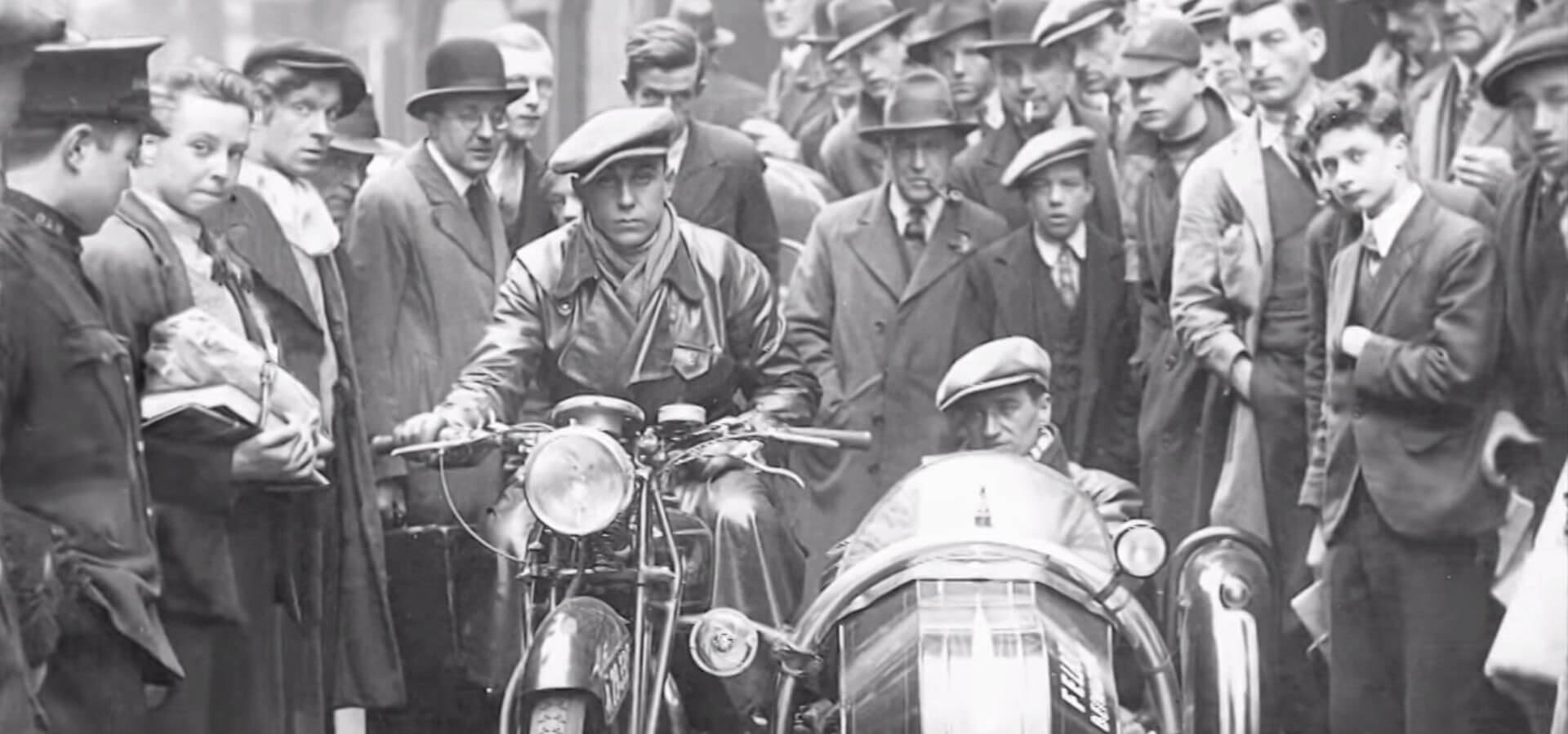 Giovane Karl Abarth in sella a una moto con il pubblico alle spalle